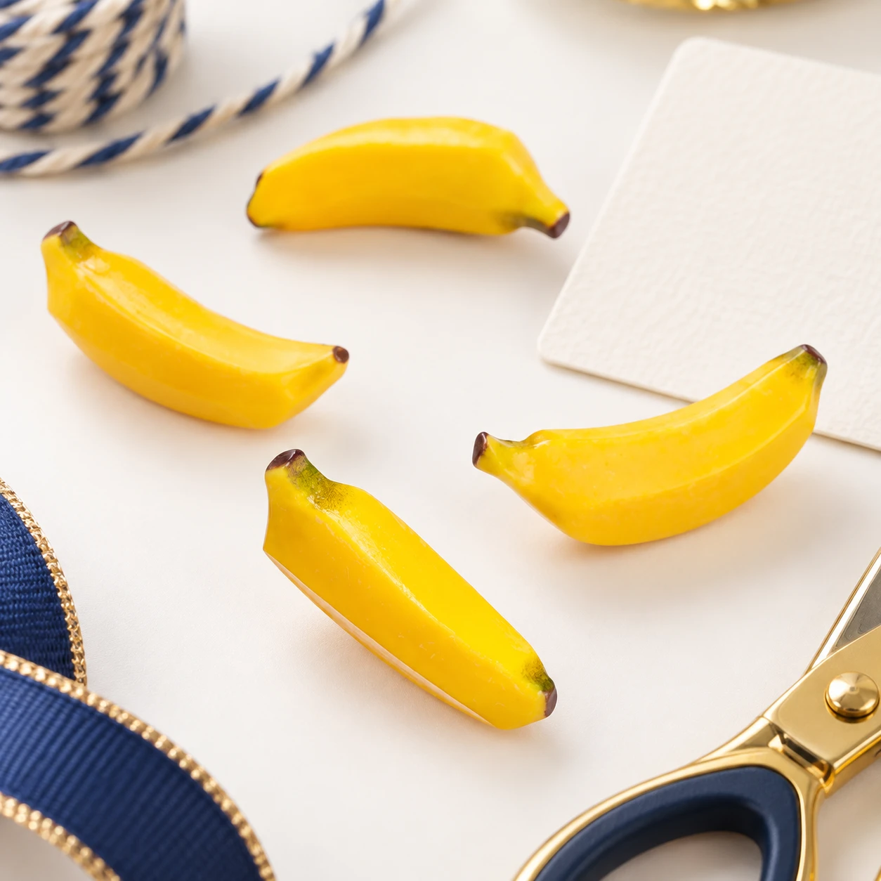 Mini Banana Resin Charms RW003268 in an illustrative craft workspace